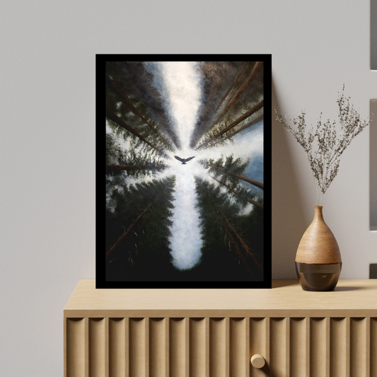 A framed vertical art print depicting a bird flying through a forest canopy, leaning against a light gray wall on a light wood cabinet next to a decorative vase.