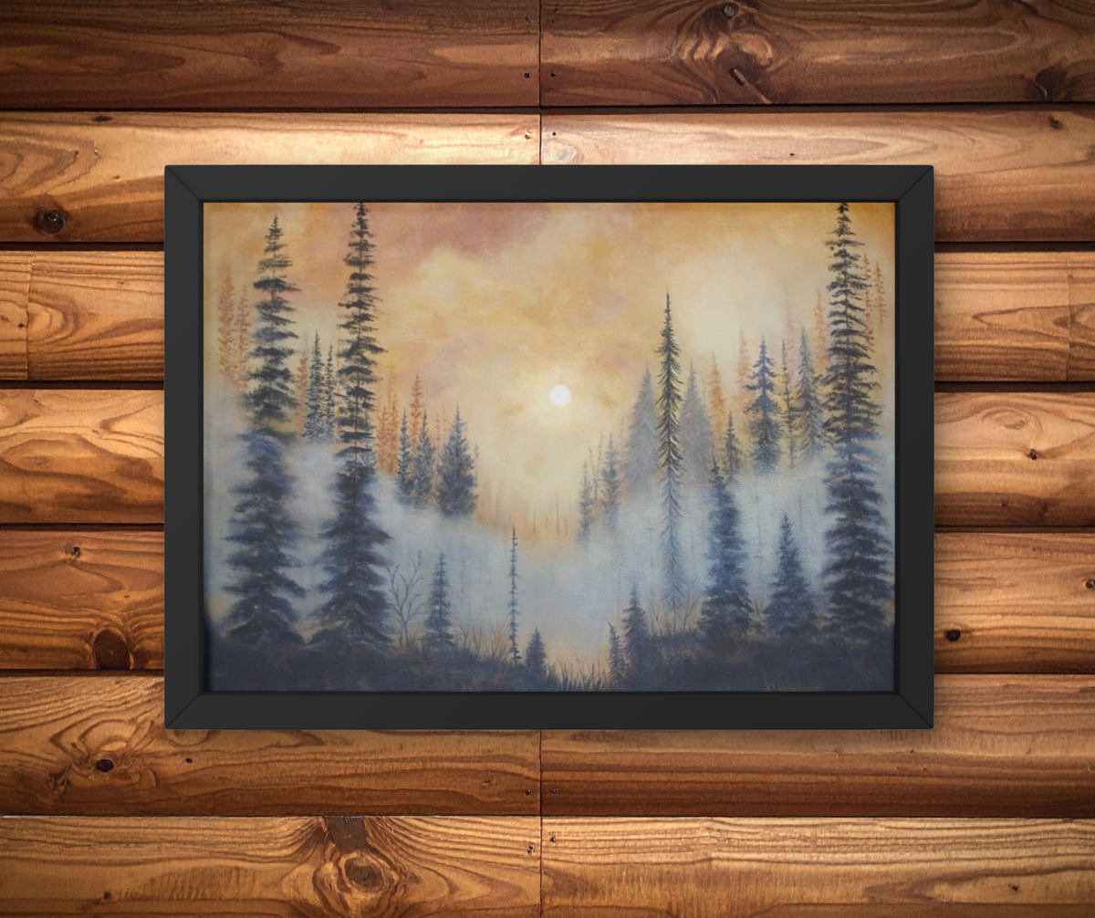 A framed landscape painting of a misty pine forest at sunrise or sunset, displayed on a rustic wood plank wall. The painting features dark evergreen trees against a warm yellow and orange sky with a soft blue-gray fog layer.